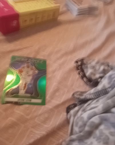 Green holographic card with a figure in white outfit — front