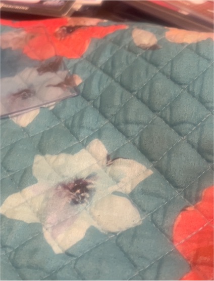 quilted floral fabric with teal background and white and red flowers — front
