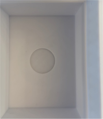 Empty white box with circular indentation — front